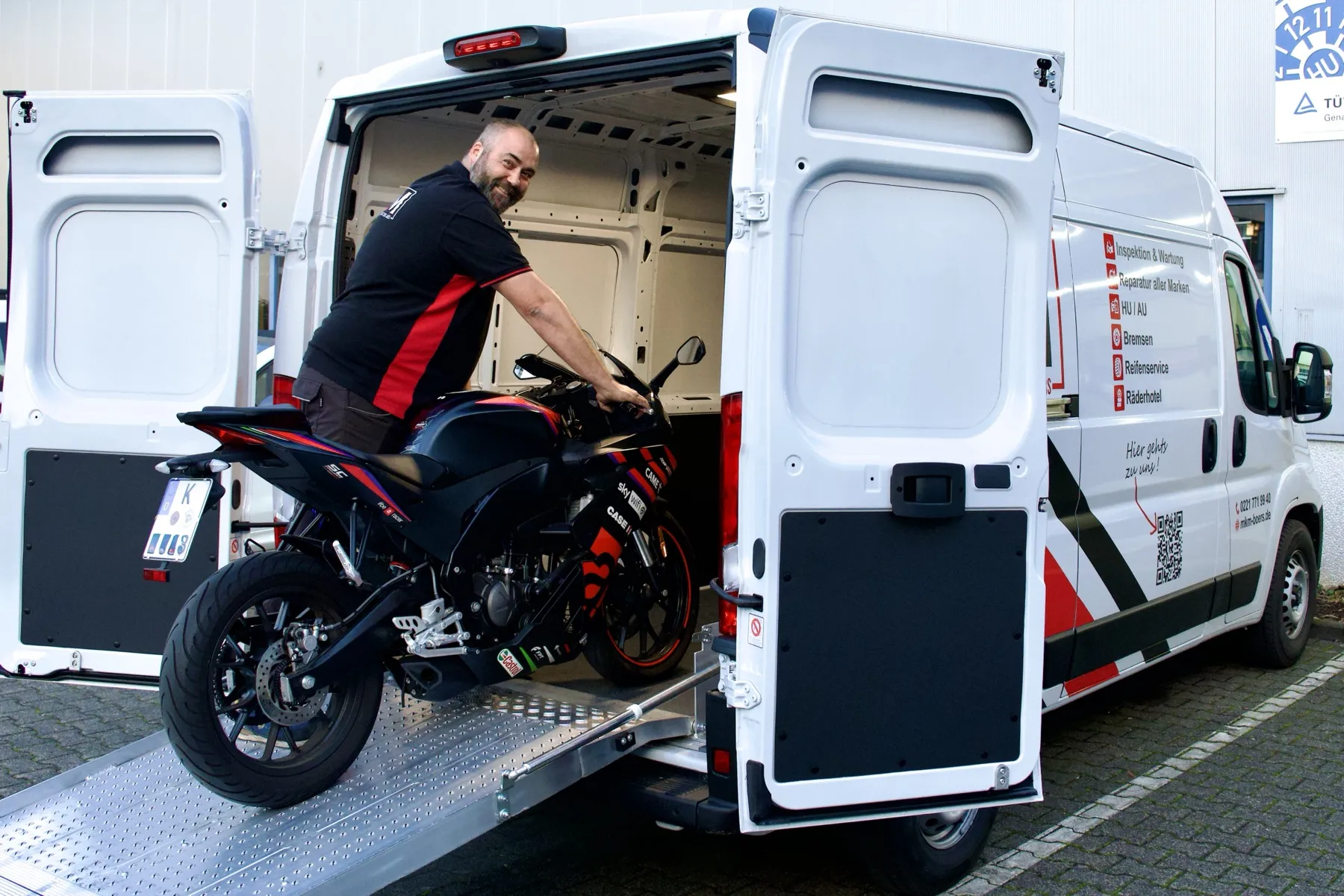 Hol- und Bringservice von MKM Börs: Ein Motorrad wird über eine Rampe in den Transporter geschoben